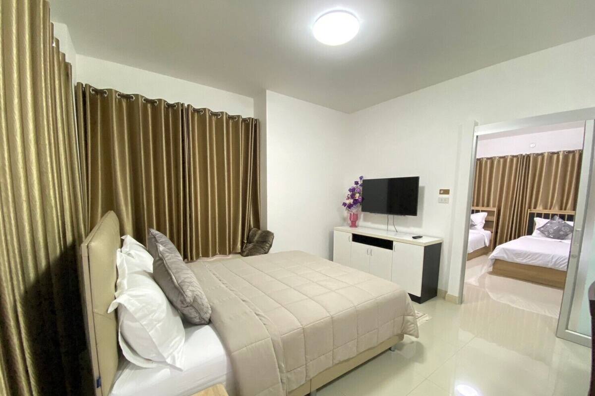 A hotel room with a bed, a TV, a desk, and a mirror.
