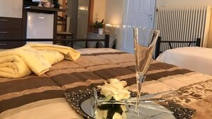 Una cama bien hecha con una bandeja decorativa, un jarrón con flores y una mesita de noche con una lámpara.