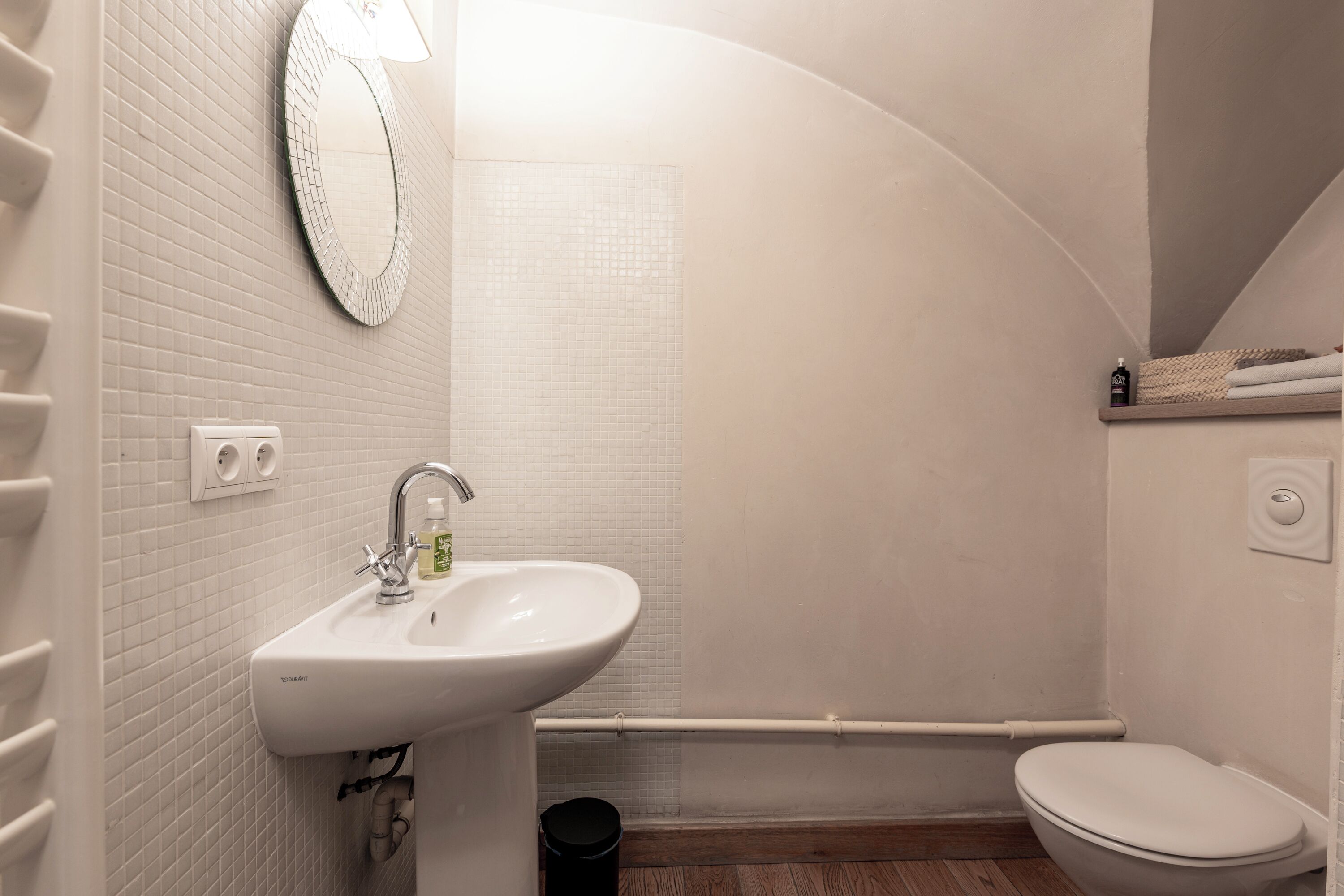 Un baño con lavamanos, espejo y retrete.