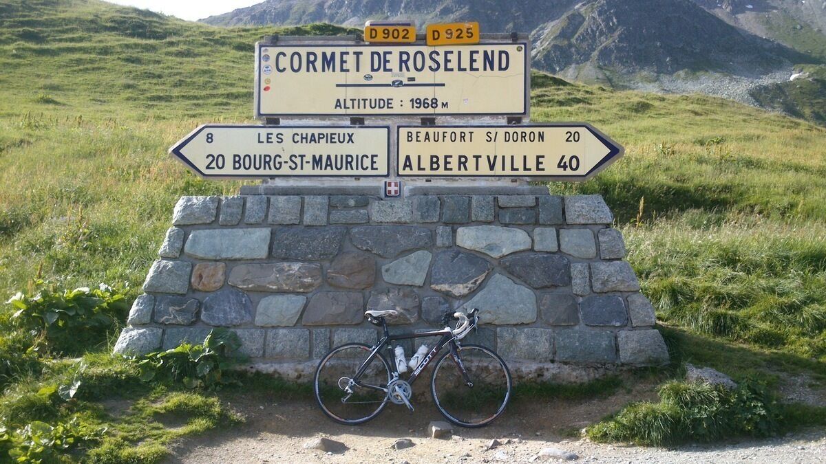 Un panel de señalización con indicaciones hacia varios destinos, incluyendo Cormet de Roselend, Les Chapieux, Bourg-St-Maurice, Beaufort y Albertville.