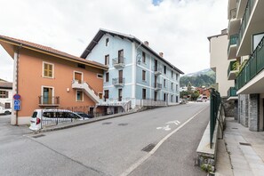 Une rue bordée d’immeubles, un panneau indiquant qu’il est interdit de se garer et une piste cyclable.