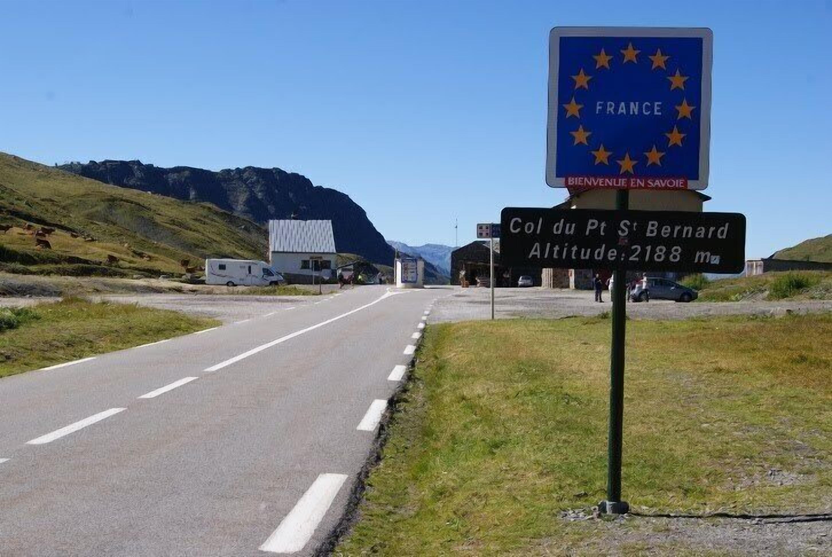 A road with a sign indicating the location 'Col du Pt St Bernard' and its altitude of 2188 meters.