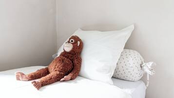 A bed with a plush toy and a pillow.