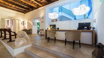 Un interior moderno con techo de madera, un mostrador de recepción y una escalera que conduce a un nivel superior.