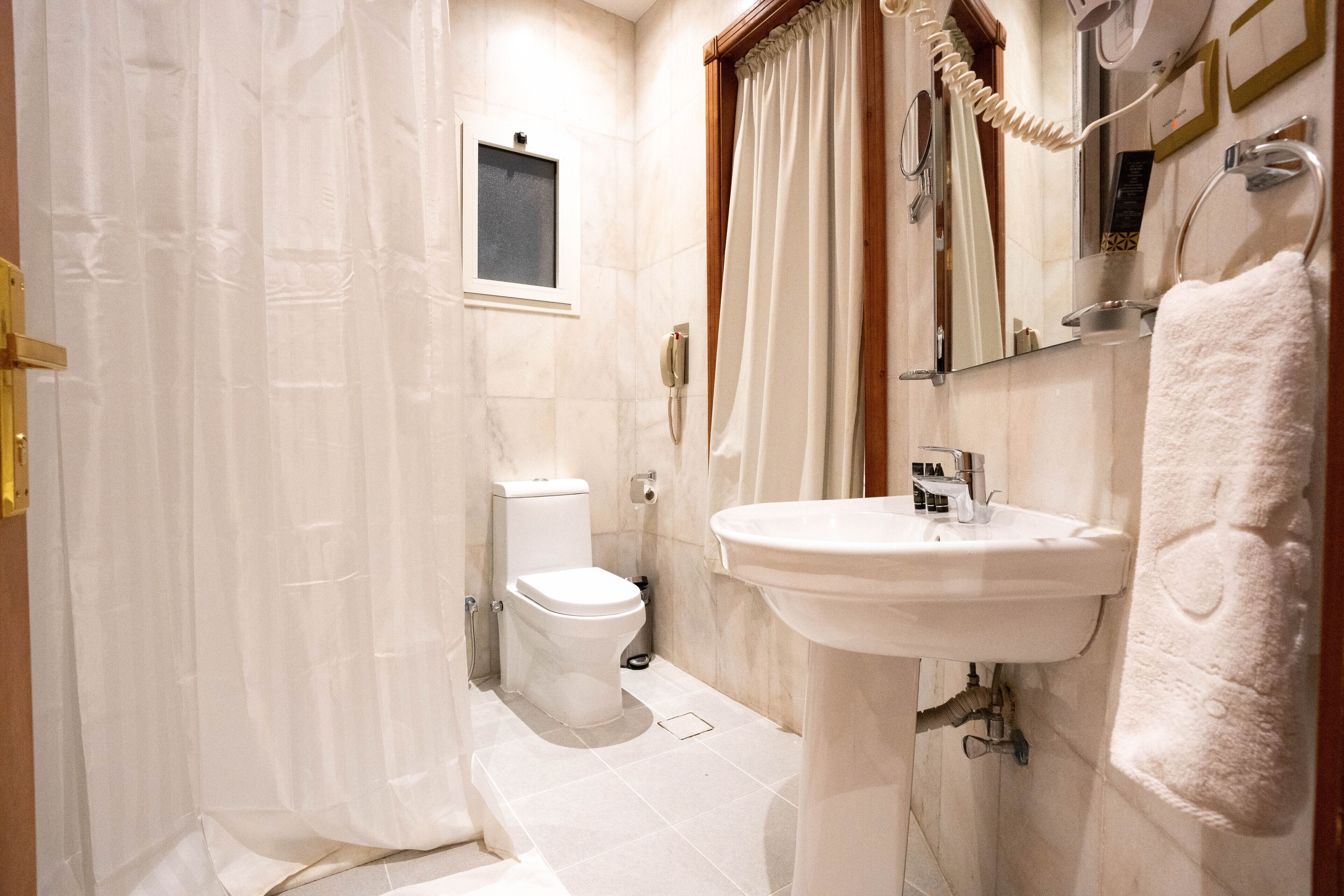 A bathroom with a toilet, sink, and shower curtain.