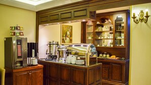 Un espace buffet équipé d’une machine à café, d’un appareil pour maintenir les plats au chaud et proposant une variété de plats.