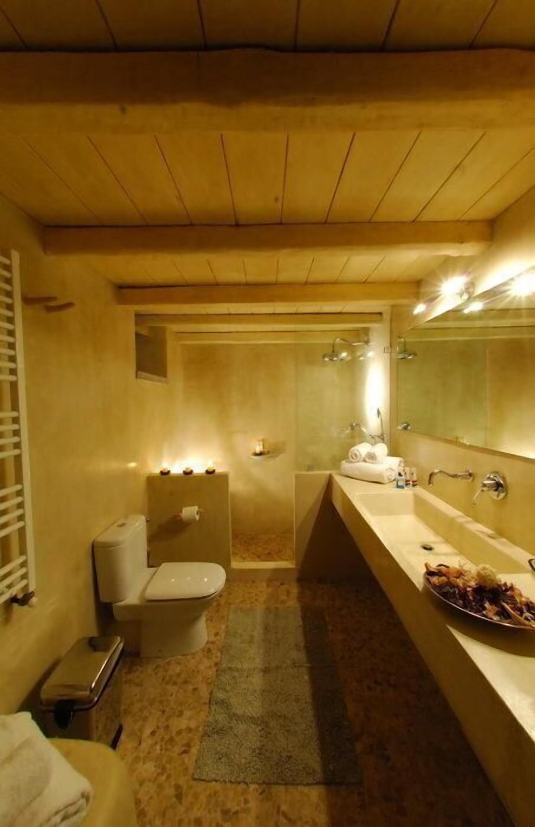 Un baño pequeño con inodoro, lavamanos y zona de ducha.