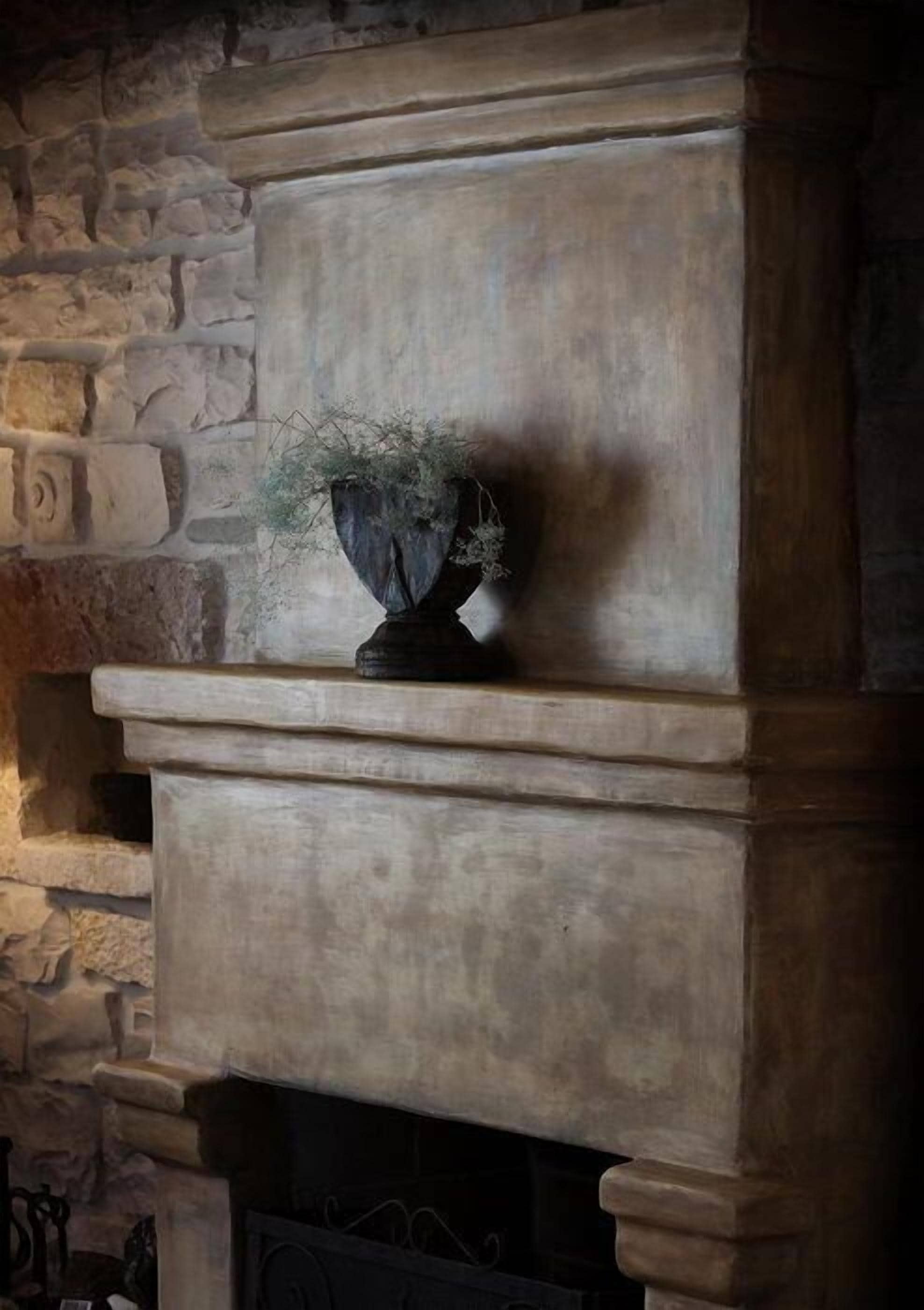 A stone fireplace with a decorative planter on the mantel.