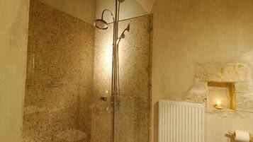 Ein Badezimmer mit Dusche, Fliesenboden und Heizkörper.