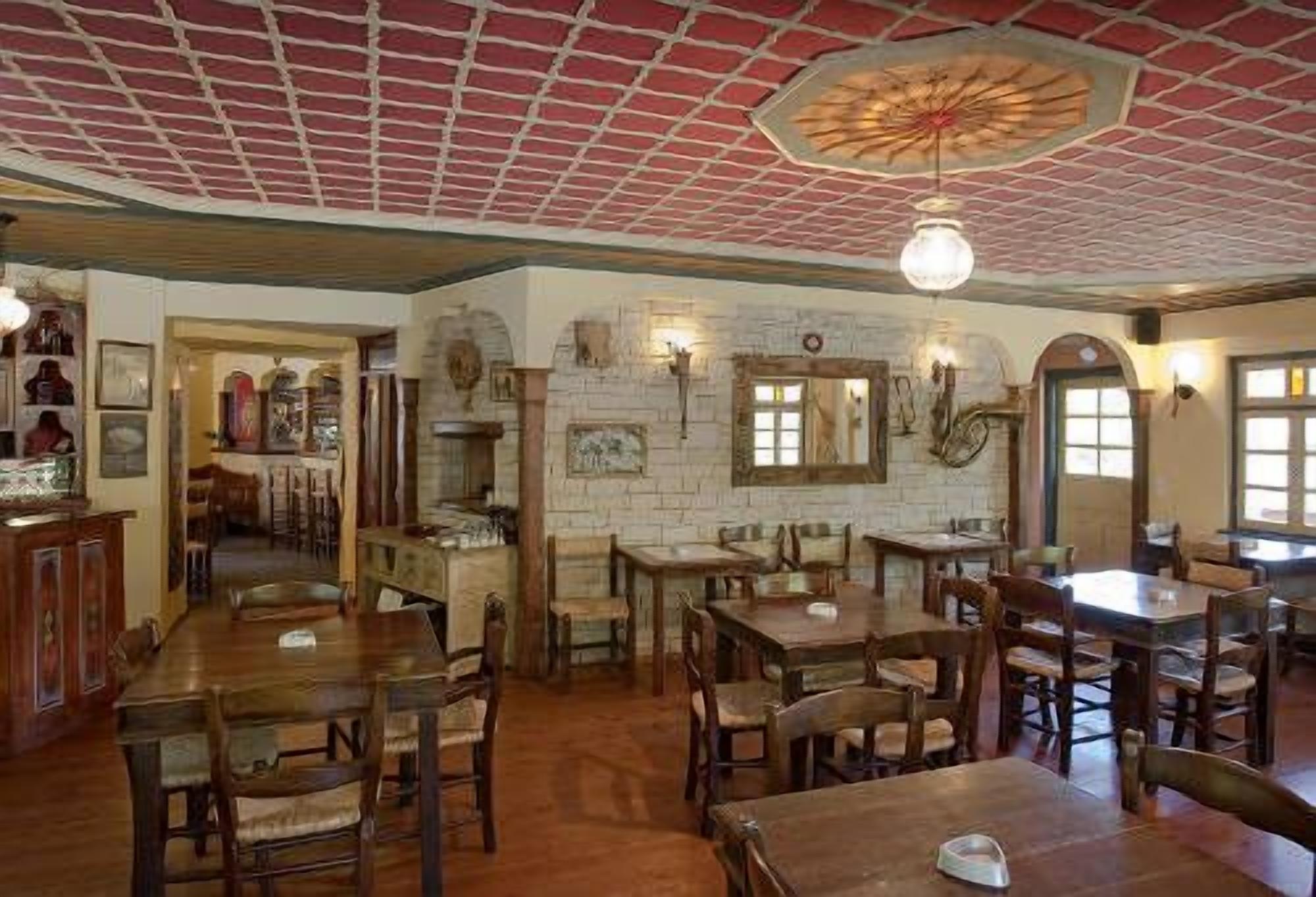 A restaurant with wooden tables and chairs, a brick ceiling, and wall-mounted lights.