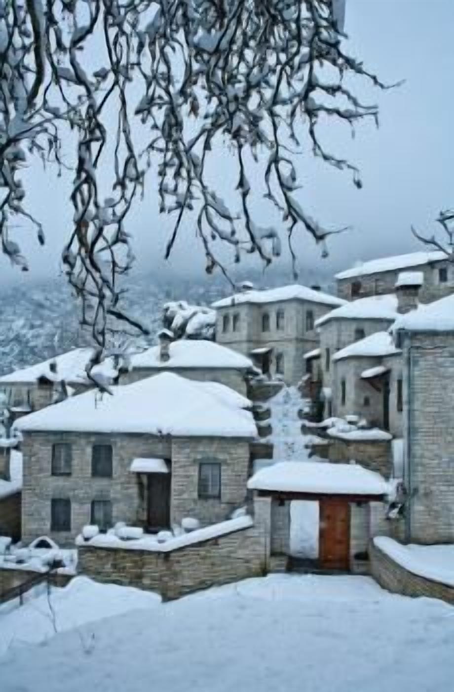 Un pueblo cubierto de nieve con edificios de piedra tradicionales, calles estrechas y un ambiente rústico.