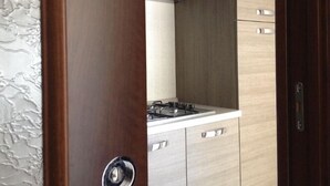 A kitchen with a gas stove, wooden cabinets, and a stainless steel range hood.