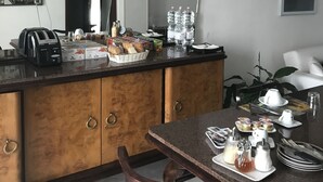 A modern kitchen with a dining area, featuring a countertop with a toaster, bread, and condiments.