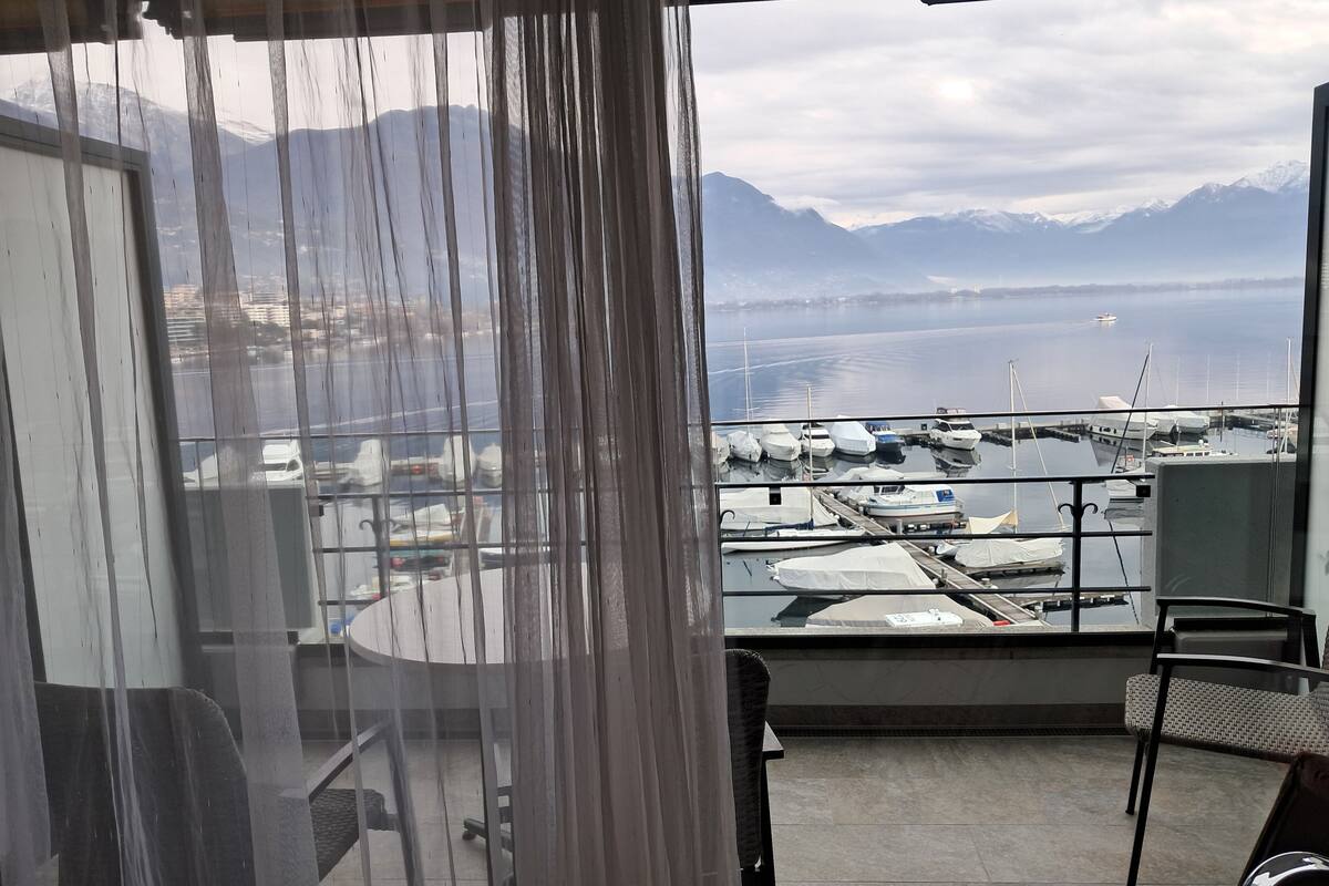 A balcony with a view of a marina and mountains.