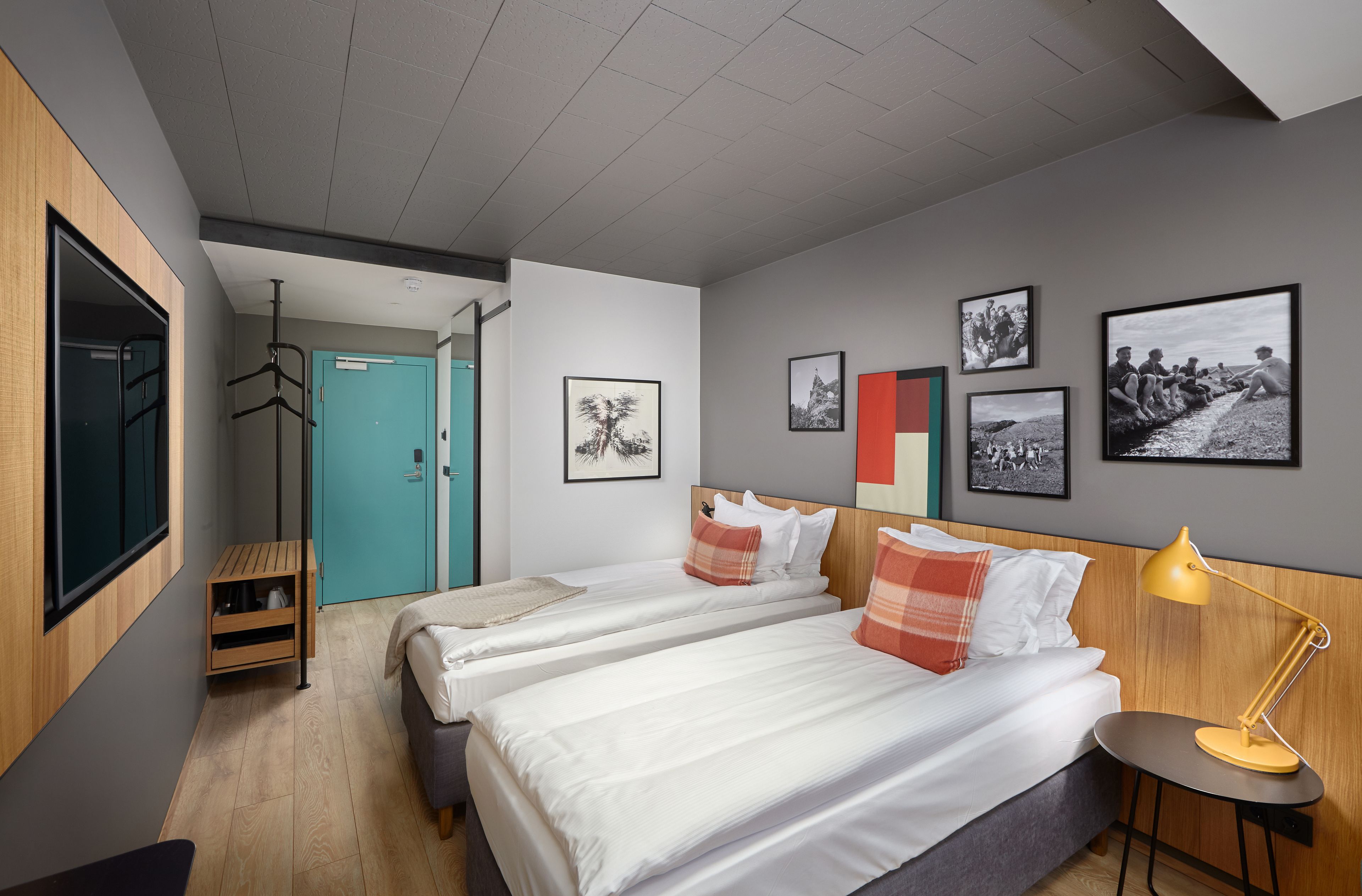 Una habitación de hotel moderna con dos camas, un escritorio y un armario.