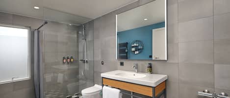 A modern bathroom with a glass shower enclosure, a white sink, and a bathtub.