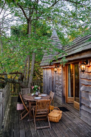 A rustic wooden cabin with a dining area, a small tower-like structure, and lanterns. - Domaine Ecôtelia (Le Nizan)