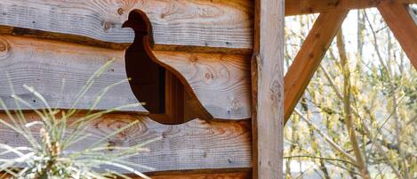 Pared de madera con un gallo de madera tallado.