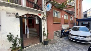 A building entrance with a sign reading "ESEN APT. NO: 7", a scooter parked outside, and a white car parked on the street. - Armoni City Hotel (Istanbul)