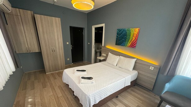 A modern bedroom with a bed, wardrobe, and a colorful artwork on the wall. - Armoni City Hotel (Istanbul)