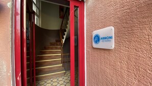 A staircase leading to a building entrance with a red door and a sign reading "ARMONi city kadirköy". - Armoni City Hotel (Istanbul)