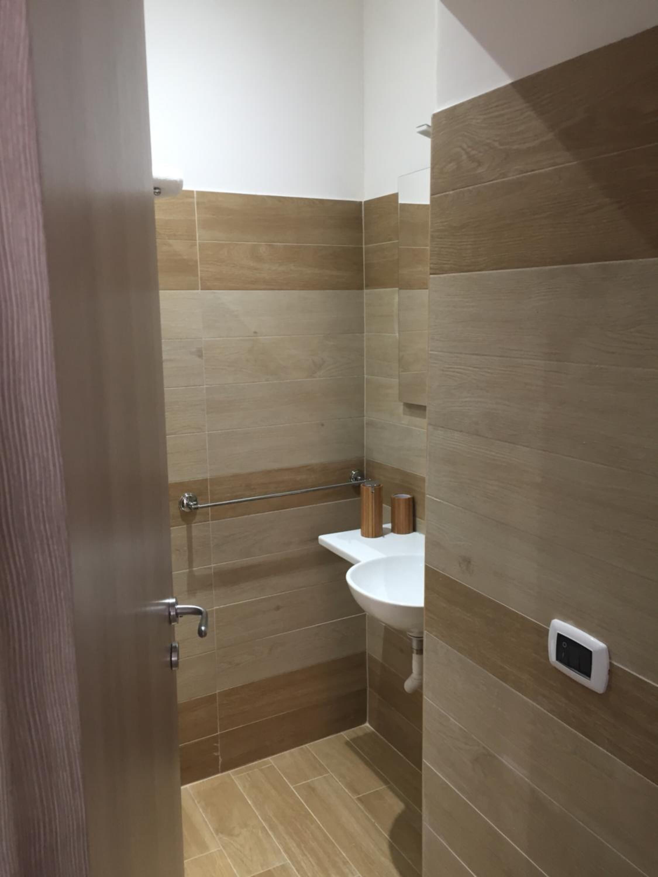 Een badkamer met een douche, wastafel en toilet.