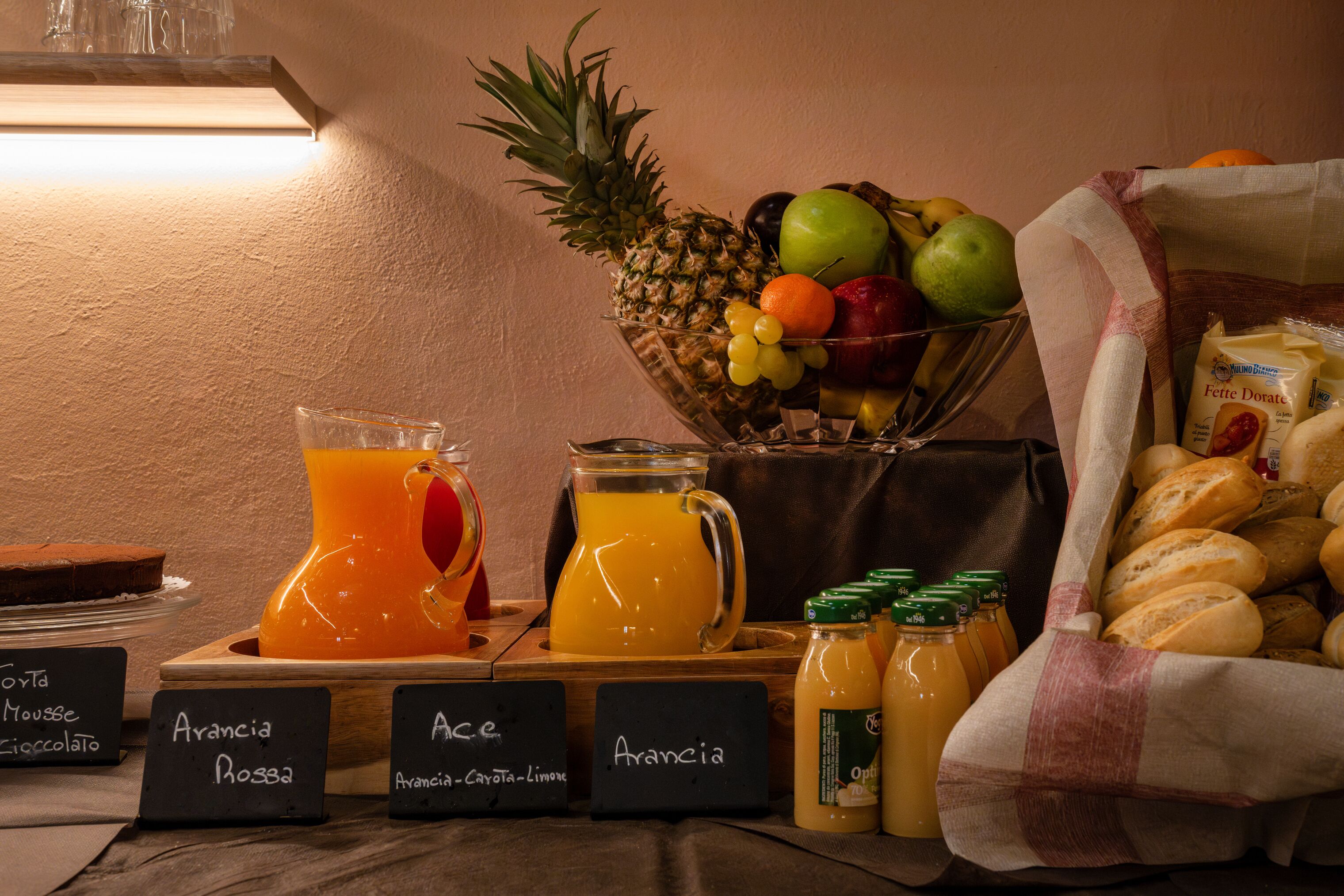 Un buffet de petit-déjeuner proposant une variété de fruits, de jus et de pains.