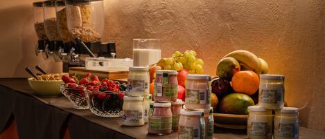 Una mesa de buffet con diversas opciones de comida, como frutas, yogur y granola.