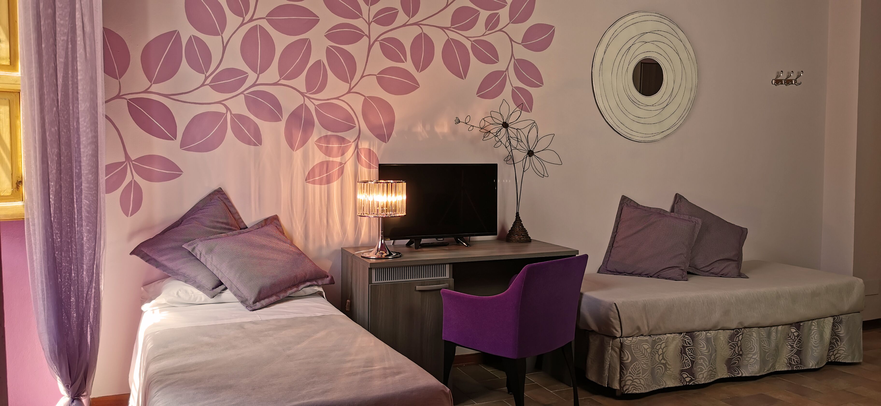 Une chambre avec deux lits, un bureau, une chaise et un téléviseur.
