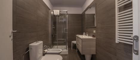 Un baño moderno con inodoro, bidé y ducha.