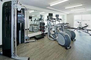 A gym with cardio machines, weightlifting equipment, and a mirrored wall. - Holiday Inn Hotel & Suites Calgary Airport North by IHG (Calgary)