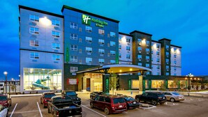 Un hotel Holiday Inn & Suites con un estacionamiento y un Burger King al otro lado de la calle.