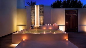 A spa area with a rectangular pool, candles, and a wooden door. - The Ritz-Carlton Ras Al Khaimah, Al Hamra Beach (Ras Al Khaimah)