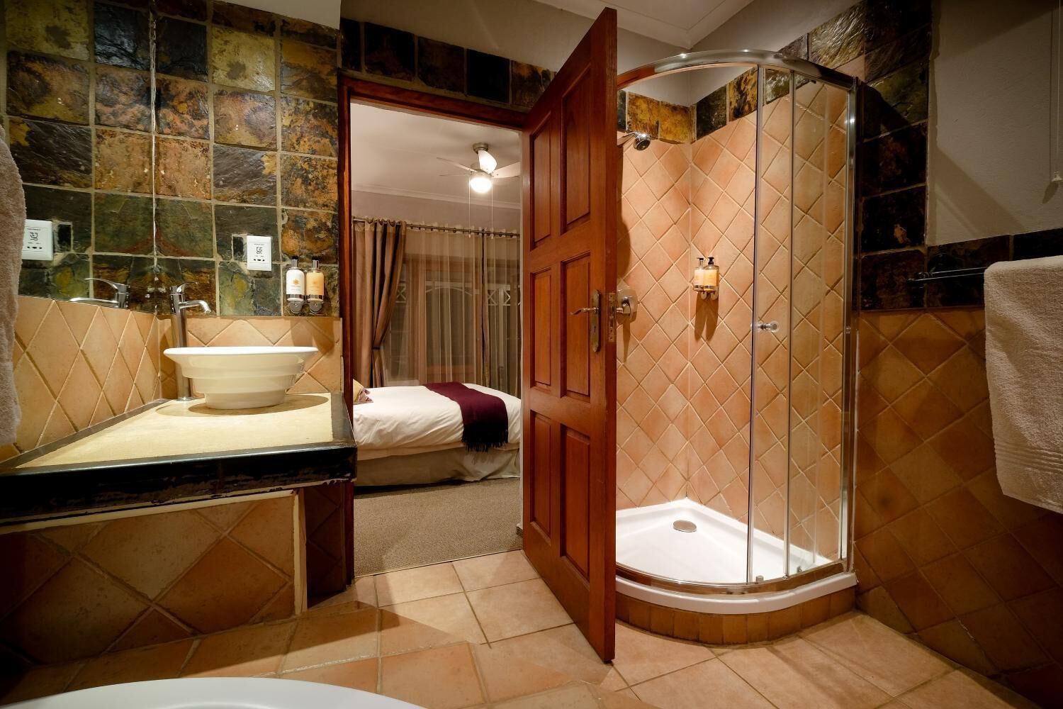 Un baño con ducha, lavabo y cama.