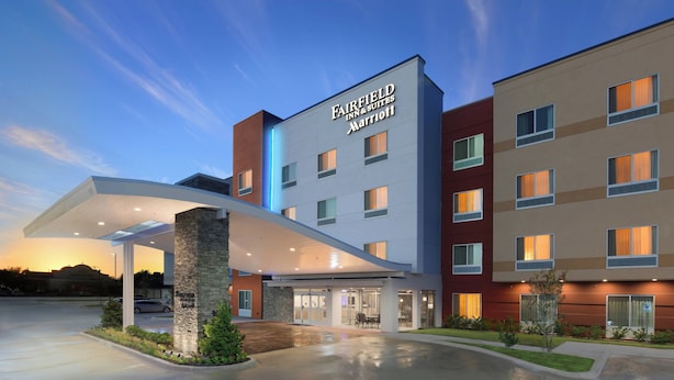 Un hotel Fairfield Inn & Suites Marriott con un diseño moderno, que presenta una entrada cubierta y una fachada bien iluminada.
