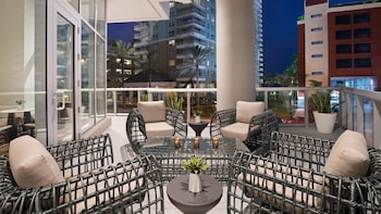 A hotel reception area with a check-in counter, a desk with a laptop, and three large paintings of cityscapes on the wall. at Hyatt Centric Brickell Miami