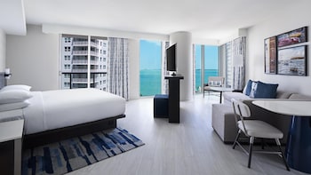 A rooftop pool with lounge chairs and palm trees, surrounded by high-rise buildings. at Hyatt Centric Brickell Miami