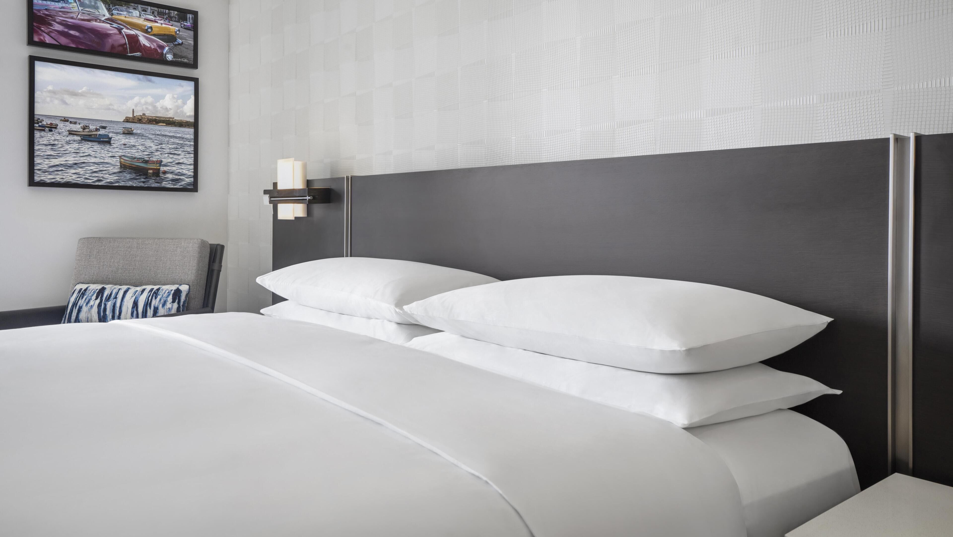 Een moderne hotelkamer met een groot bed, een nachtkastje en een wandlamp.