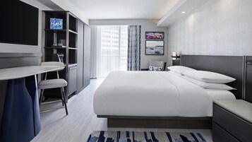 Une chambre d’hôtel moderne, dotée d’un grand lit, d’un bureau et d’une télévision.