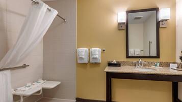 A bathroom with a shower, a sink, and a mirror.