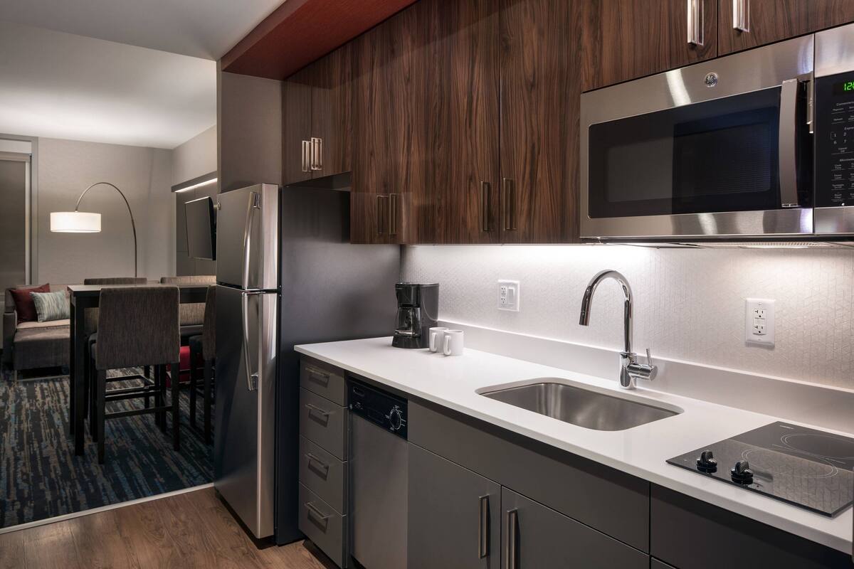 A modern kitchen with stainless steel appliances, a dishwasher, and a double sink.
