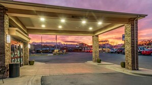 A gas station with a covered area, a kiosk, and a parking lot with cars. - Sleep Inn & Suites Moab near Arches National Park (Moab)