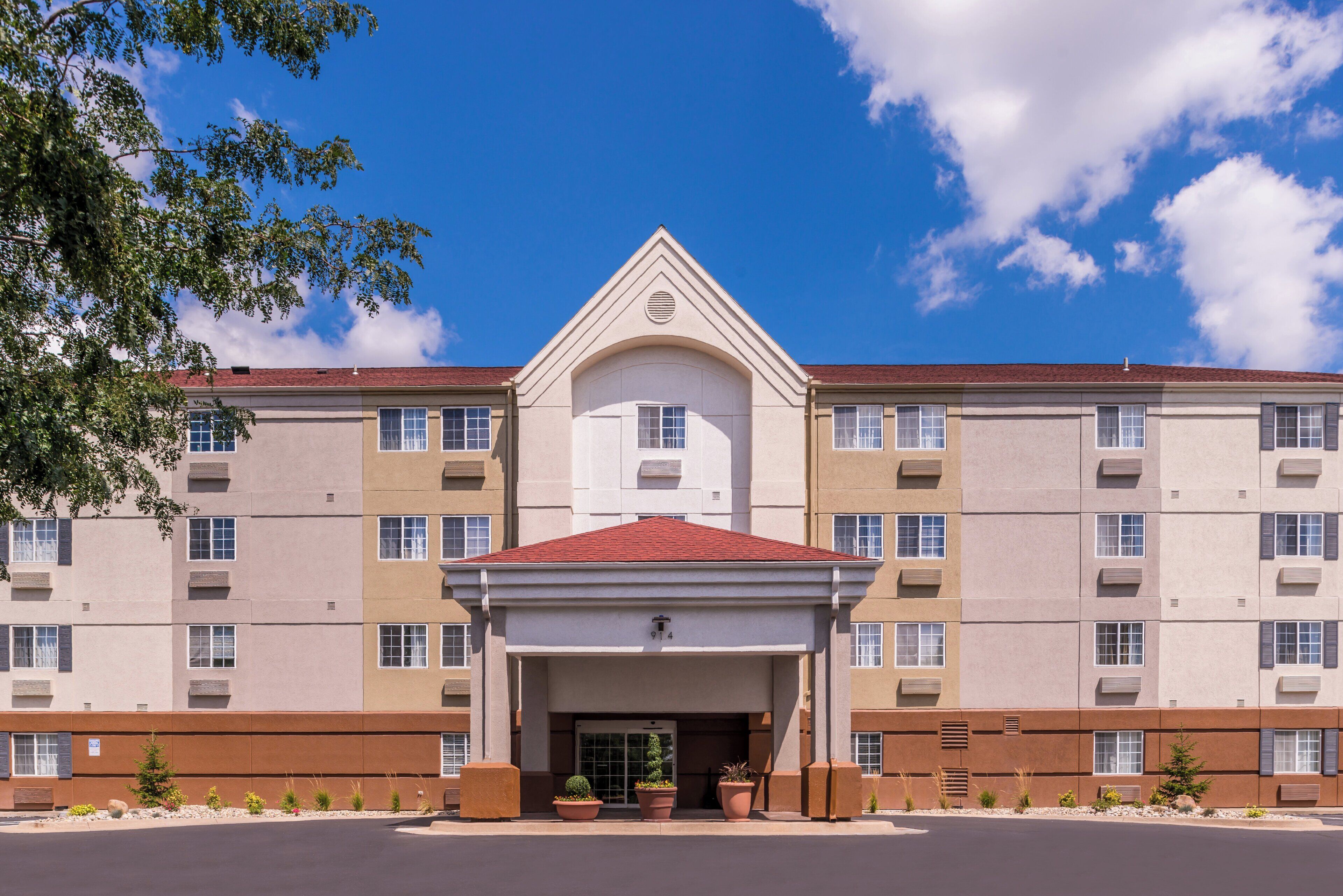A multi-story hotel with a central entrance, a red-tiled roof, and a symmetrical facade.