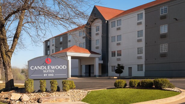 A multi-story building with a sign reading 'CANDLEWOOD SUITES BY IHG.'