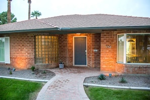 A brick house with a dark front door, a number 734, and a small garden with cacti and a potted plant. - Encanto Vistas, A Golf Property in Central Phoenix (Phoenix)