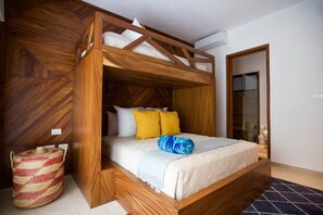 A wooden bunk bed with a white mattress, yellow pillows, and a blue blanket.