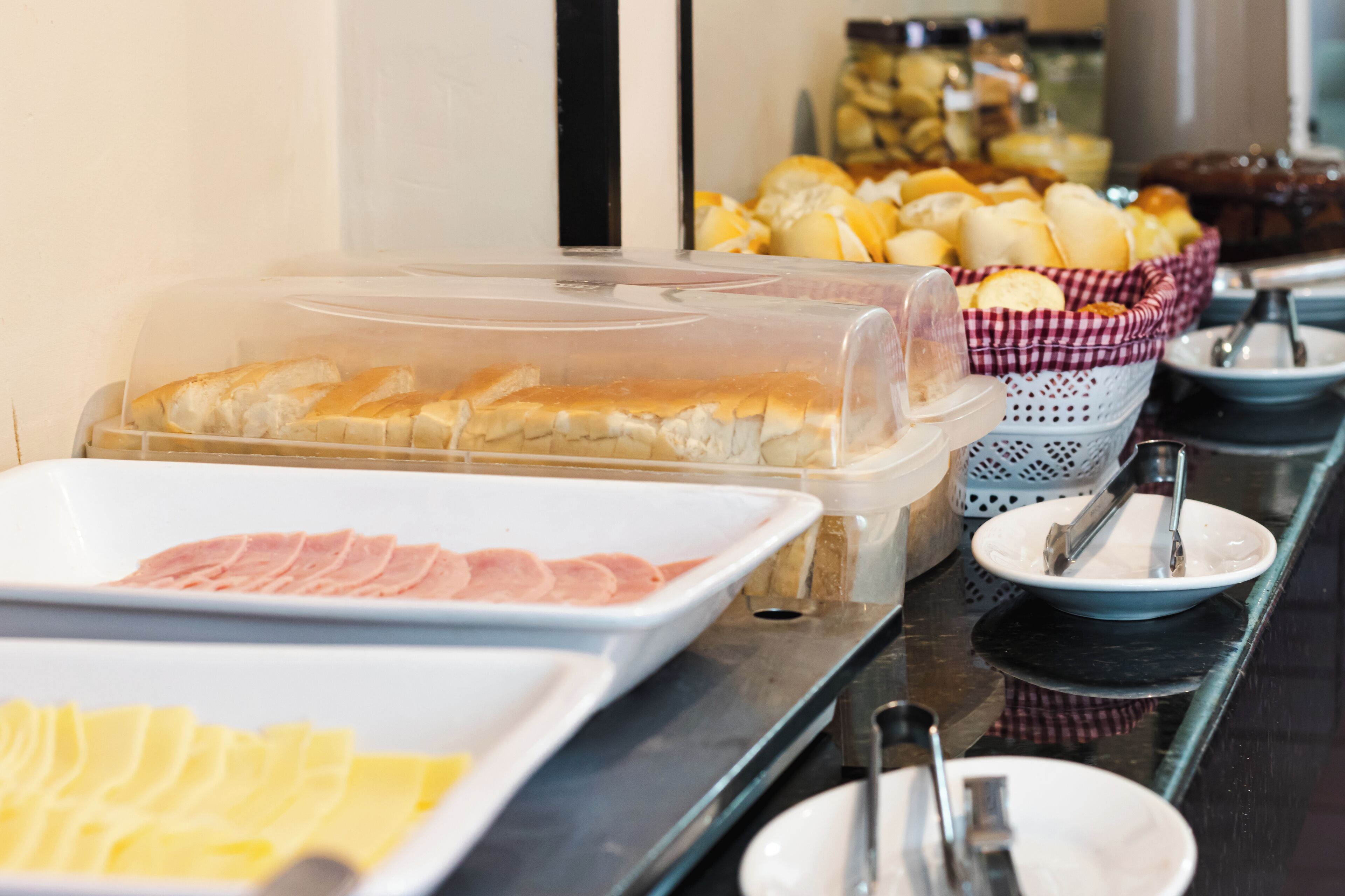 Ein reichhaltiges Buffet mit verschiedenen Speisen, darunter Brot, Schinken und Käse.