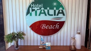 A reception desk with a sign that reads "Hotel Italia Beach." - Hotel Italia Beach (Natal)