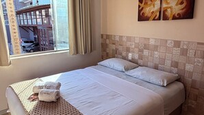 A hotel room with a large bed, a view of the outside, and two wall-mounted artworks. - Hotel Italia Beach (Natal)