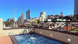A rooftop pool with a cityscape view, surrounded by buildings and a clear sky. - Hotel Italia Beach (Natal)